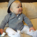 Baby wearing hooded top on sofa